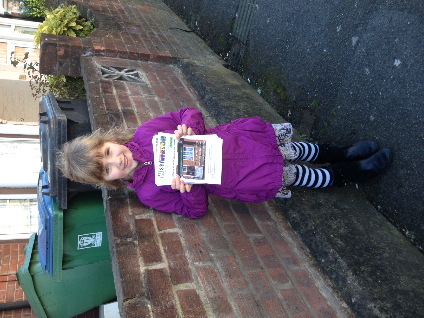 A young volunteer helping to deliver our newsletter WestWatch with her parents.  